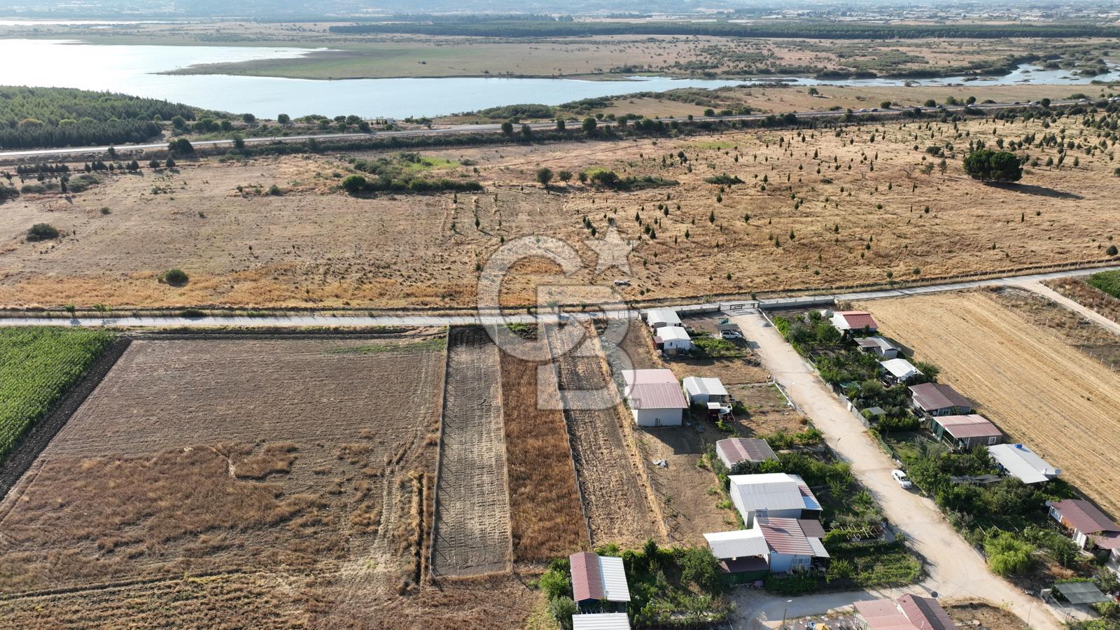 KUŞADASI ANAYOLUNA YAKIN 980 m² ETRAFI ÇEVRİLİ HİSSELİ TAPU